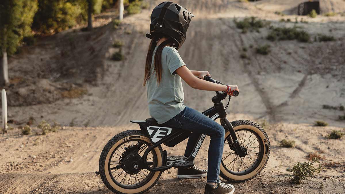 Young rider on her black SUPER73 K1D kid's e bike on a dirt track 