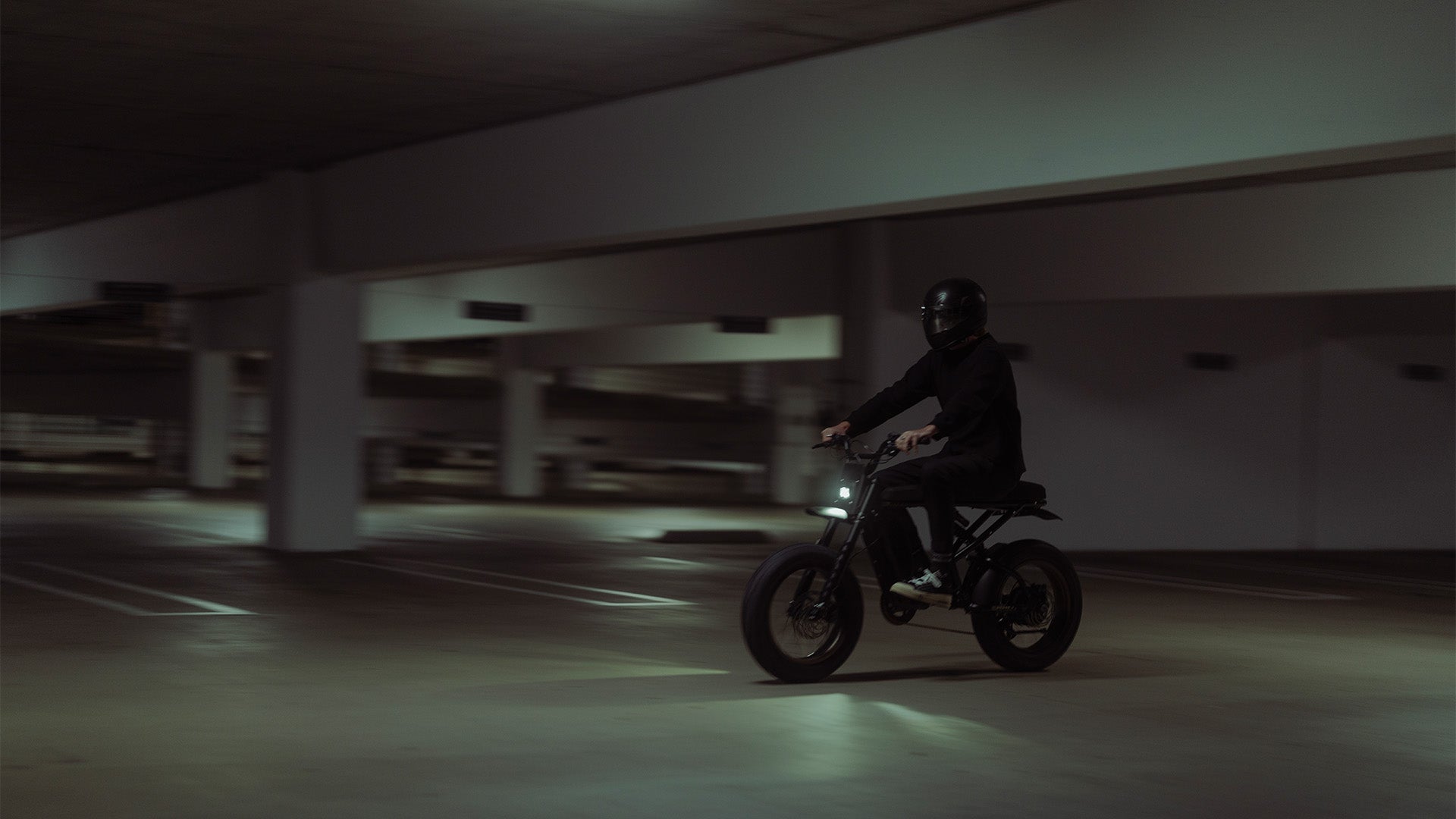 Lifestyle image of a man in a helmet riding a SUPER73-R Adventure SE ebike in Bandit