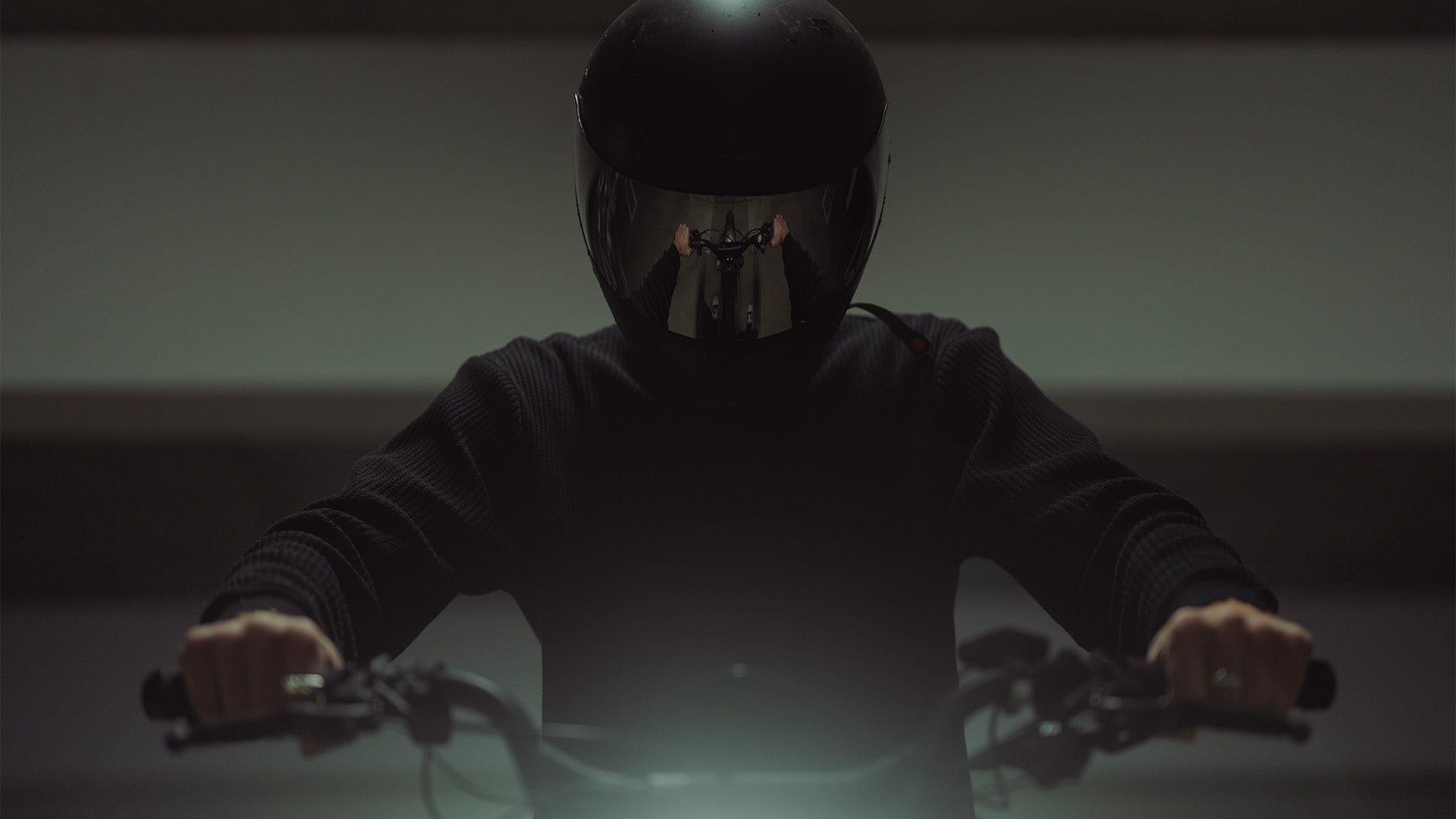 Lifestyle image showing the handlebars on a SUPER73-R Adventure SE ebike reflected in the rider's helmet