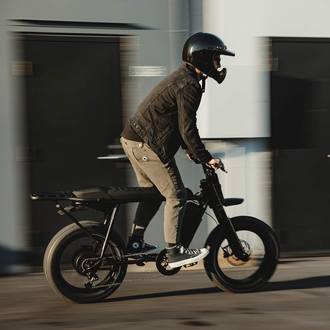 Image of a rider with a helmet riding a SUPER73-S Blackout SE bike.