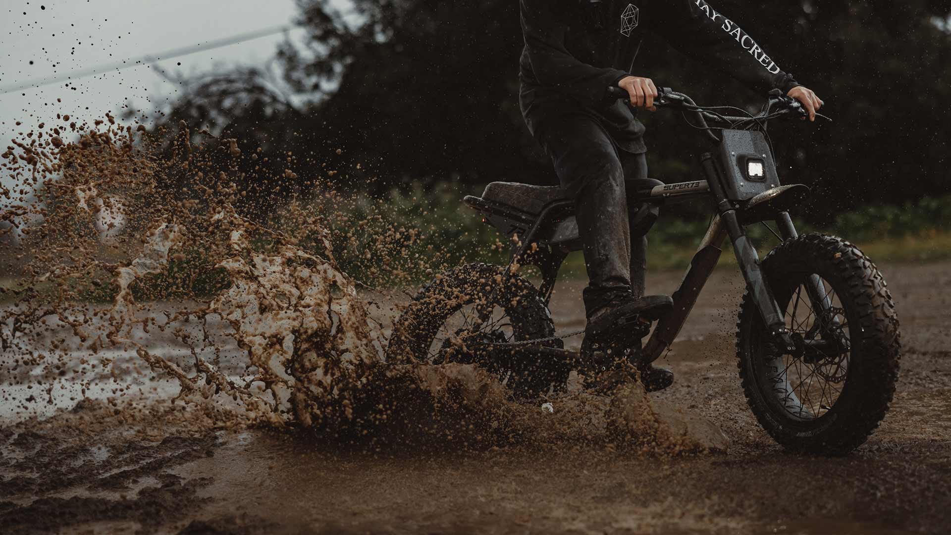 A rider on a Super73 Adventure Series ebike riding through the mud