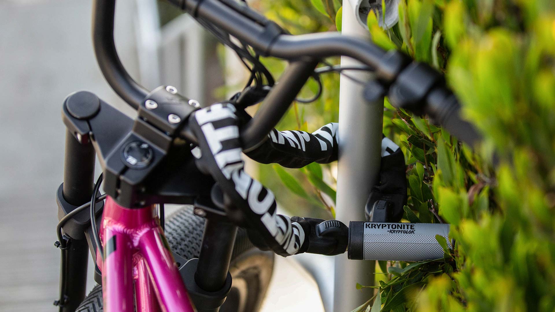 Bike locked up against a metal pole with the lock laced through the front handlebars