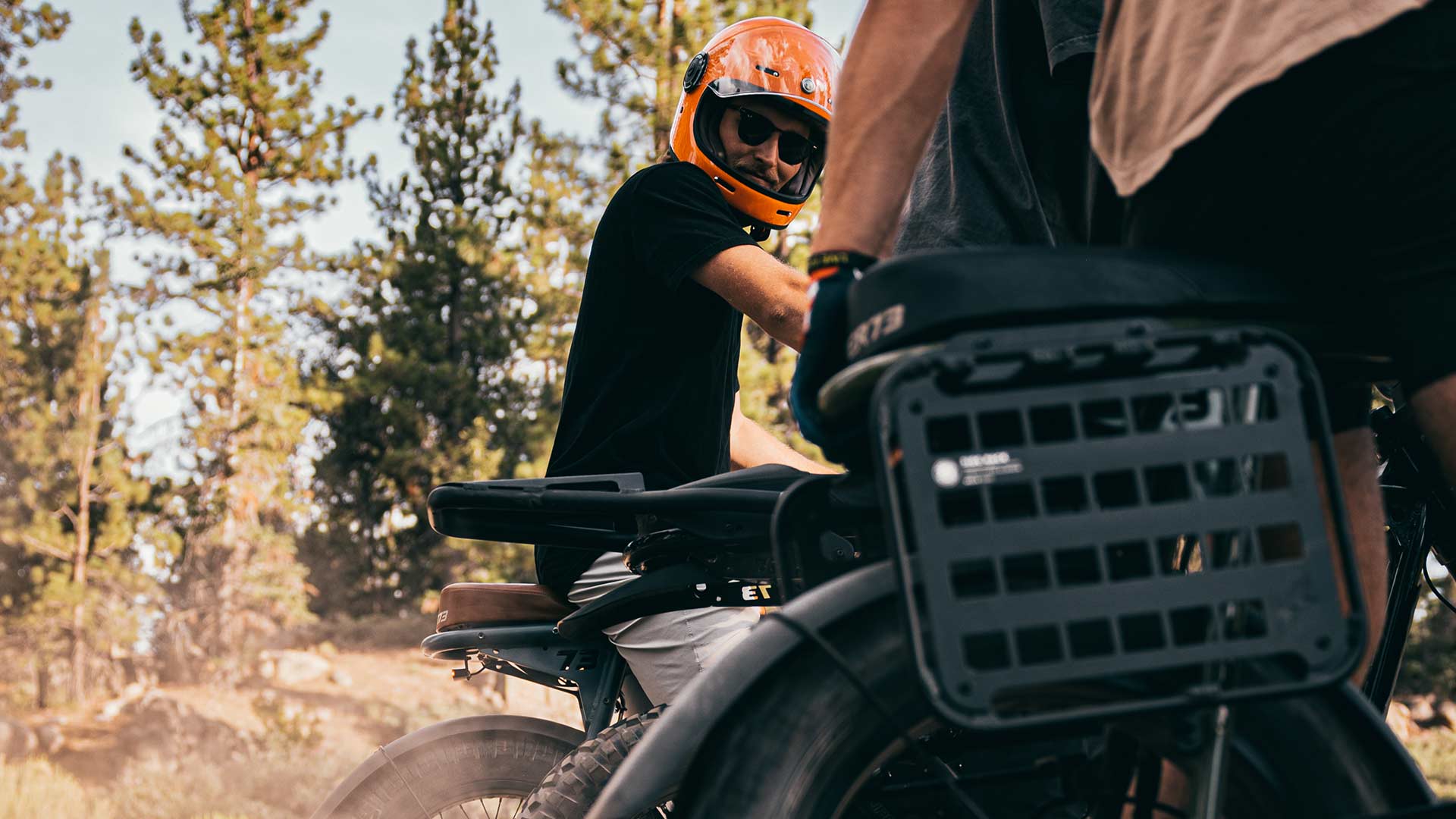 Super73 ebike rider in orange helmet fully accessorized.