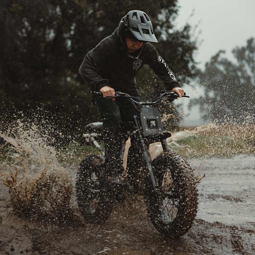 Male rider riding on his Z Adventure in the mud while wearing a helmet.