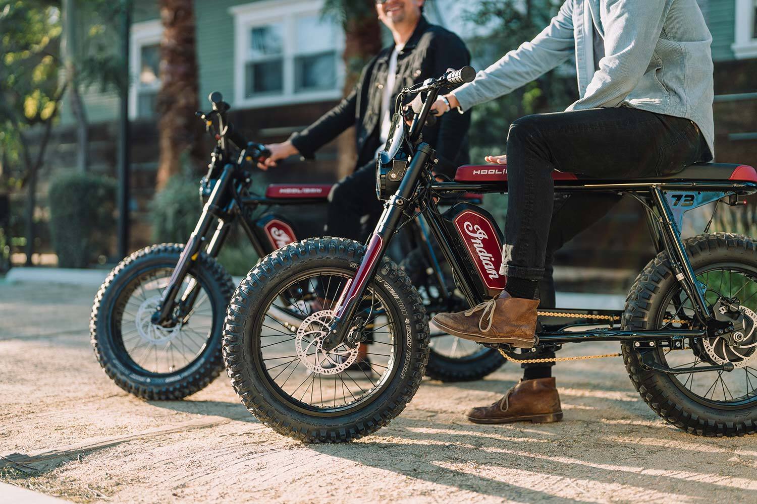 Closeup of two Indian collab vehicles side-by-side on a street with two riders hanging out.