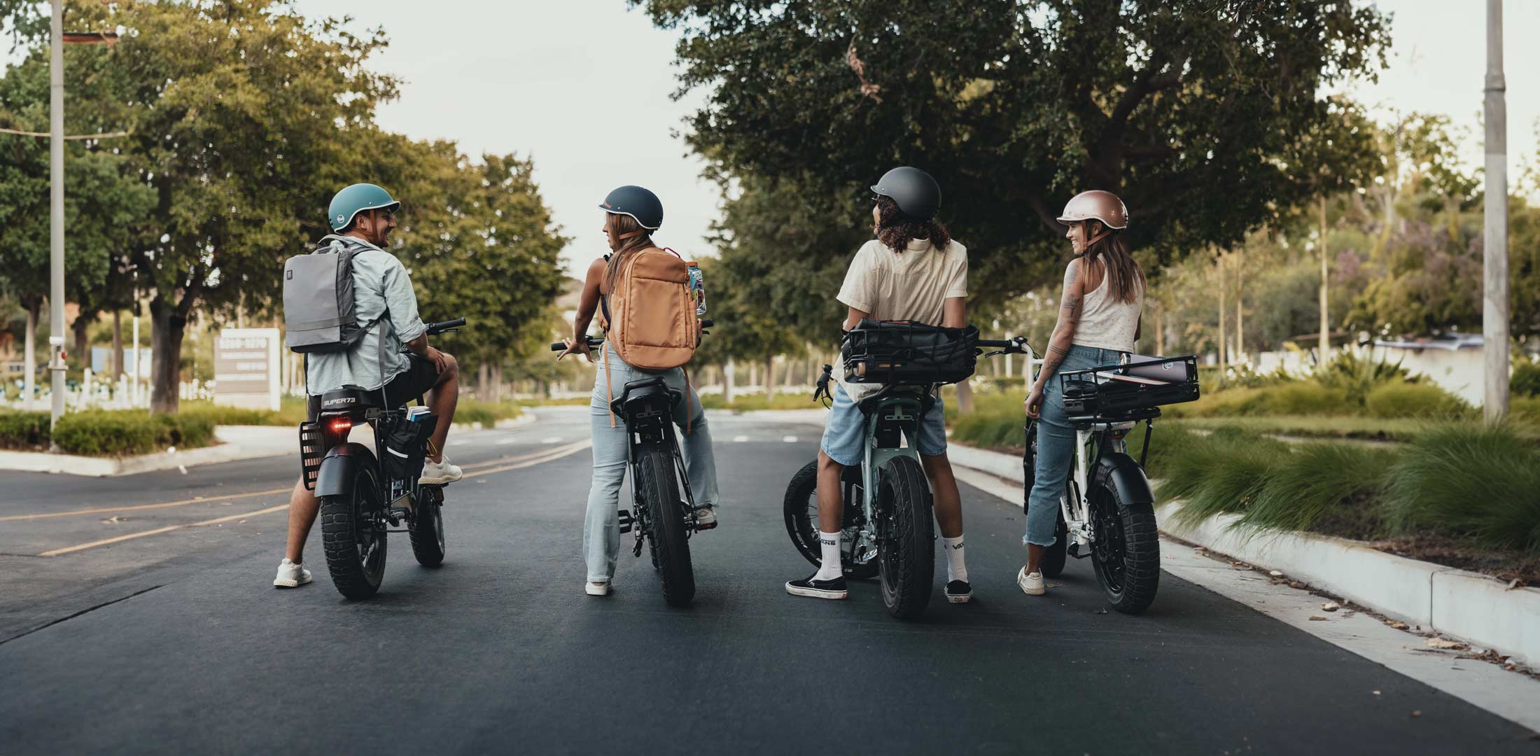 Rear view of four riders on their SUPER73 ebikes wearing Thousand helmets.