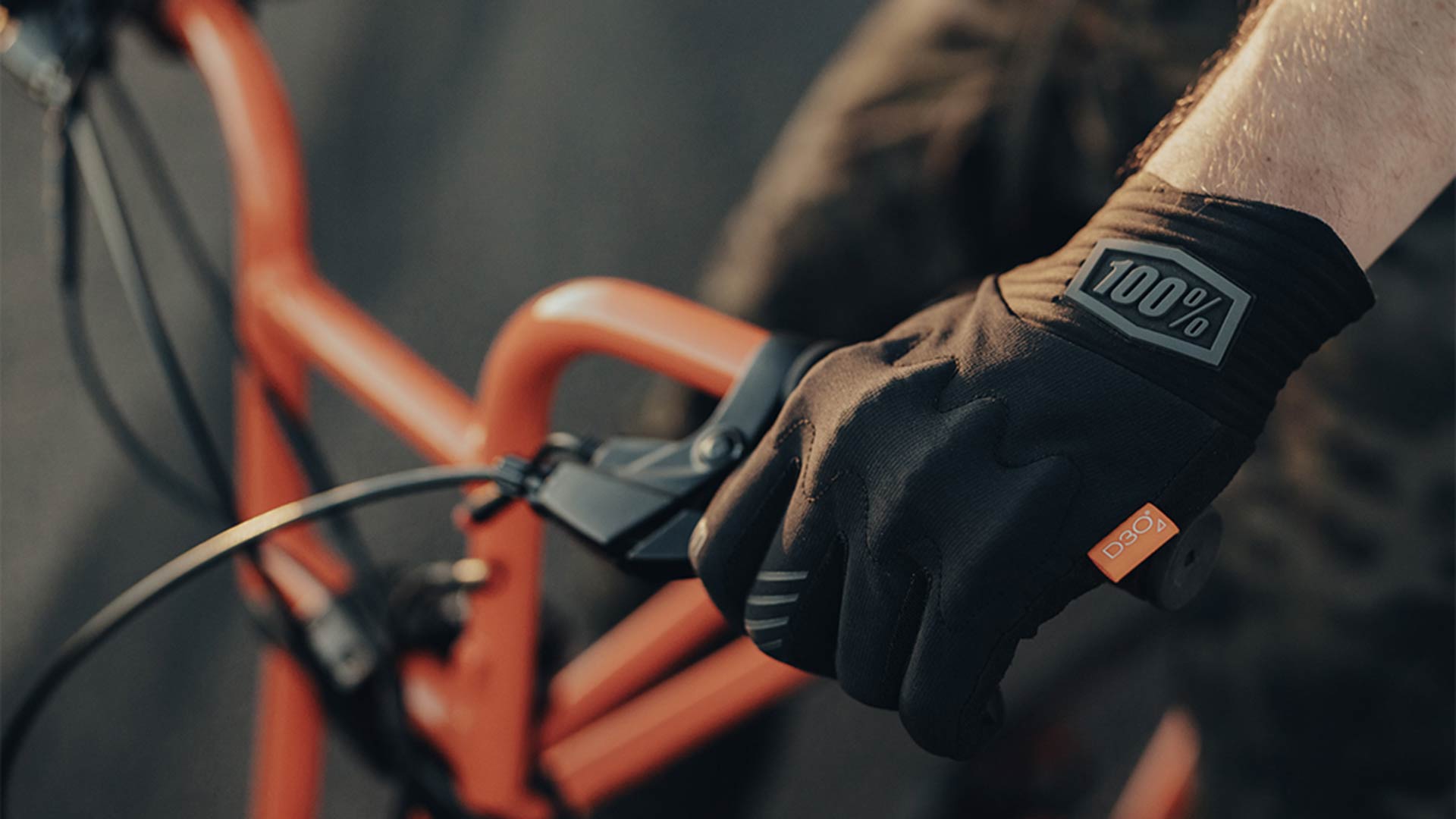 A rider wearing 100% brand gloves while riding their SUPER73 e-bike