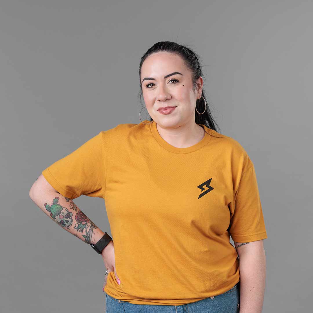 Front view of The Trailblazer Tee (Antique Gold) on female model