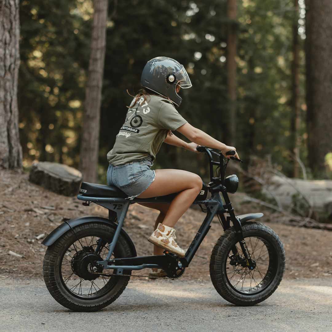 Side view of The Trailblazer Tee (Light Olive) on female model riding her SUPER73.