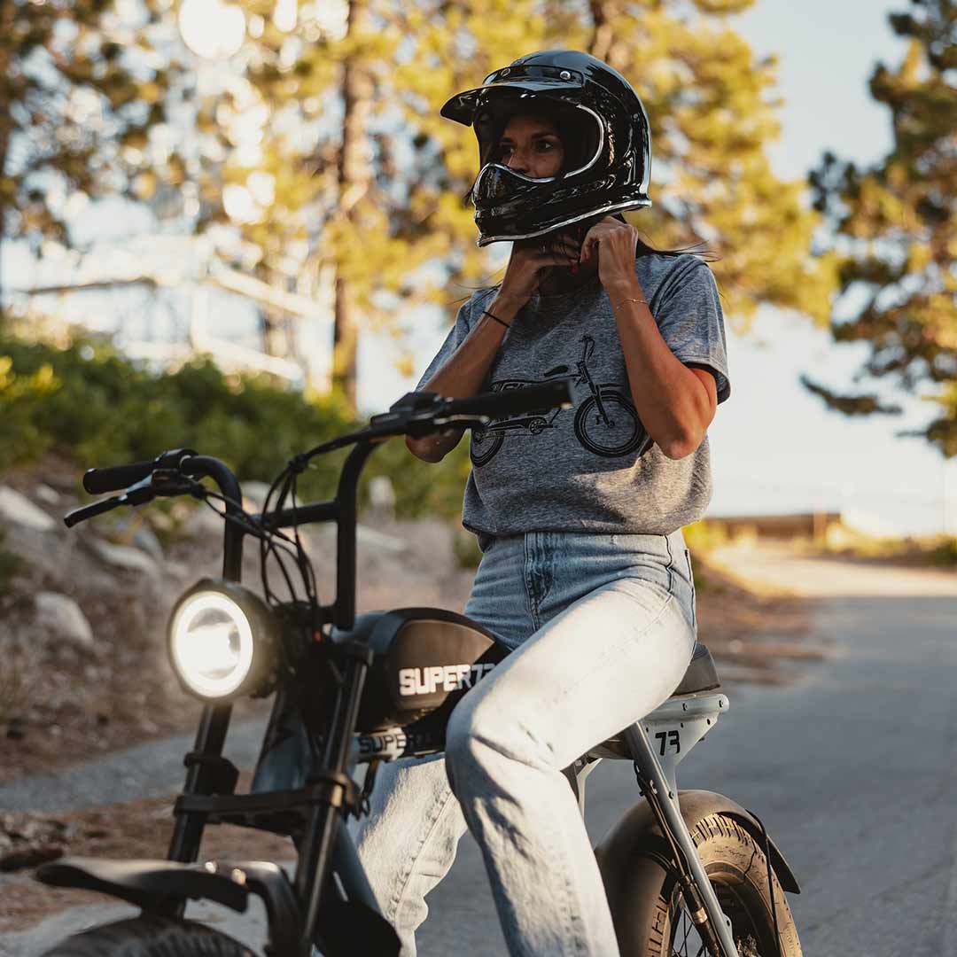 Front view of The Urban Legend Tee (Light Gray) on female model riding her SUPER73.
