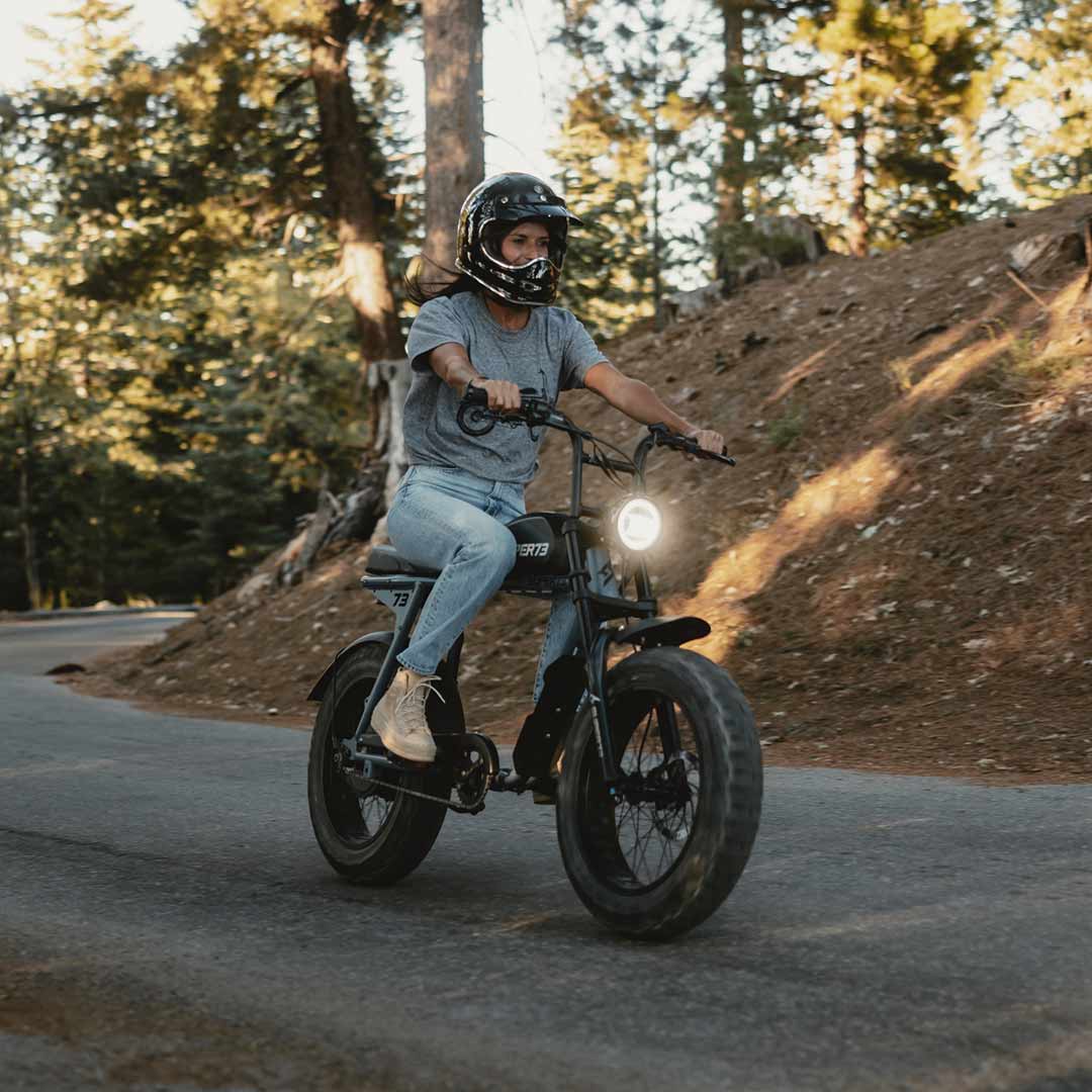 Front view of The Urban Legend Tee (Light Gray) on female model riding her SUPER73.