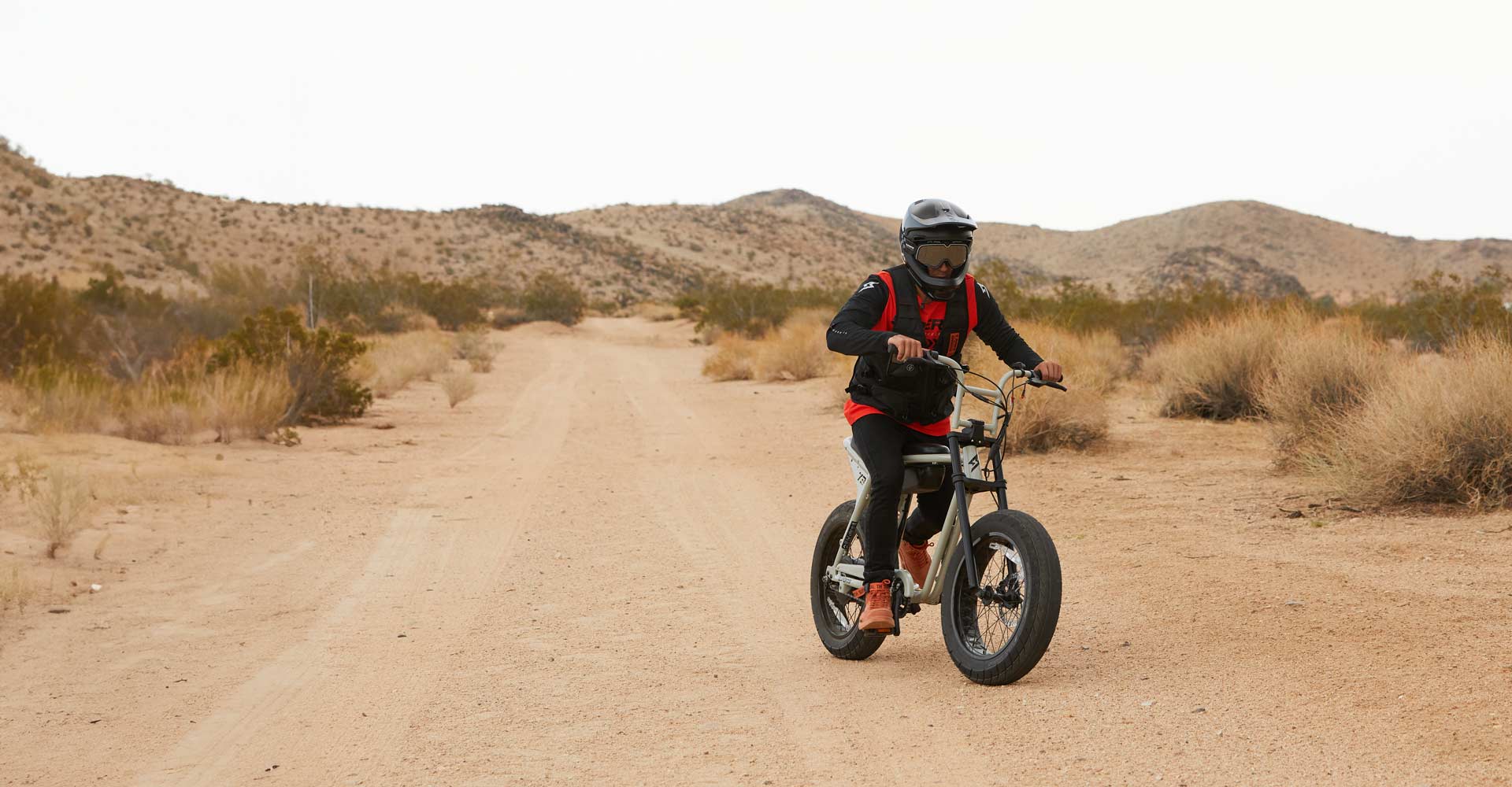 a SUPER73 rider riding out in the desert while wearing the tactical vest.