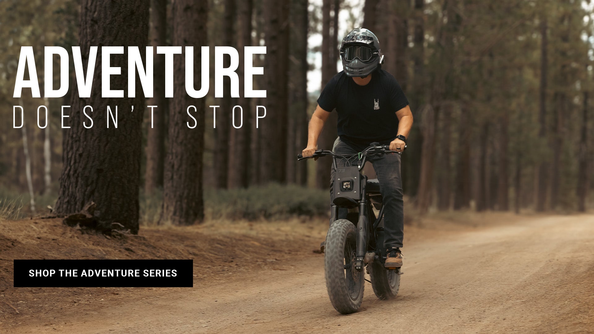 Lifestyle image of a man in a helmet riding a SUPER73-R Adventure Series ebike along a dirt path with trees lining the road.