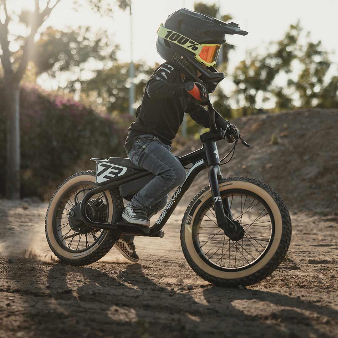 Young rider on his black SUPER73 K1D kid's e bike on a dirt track 
