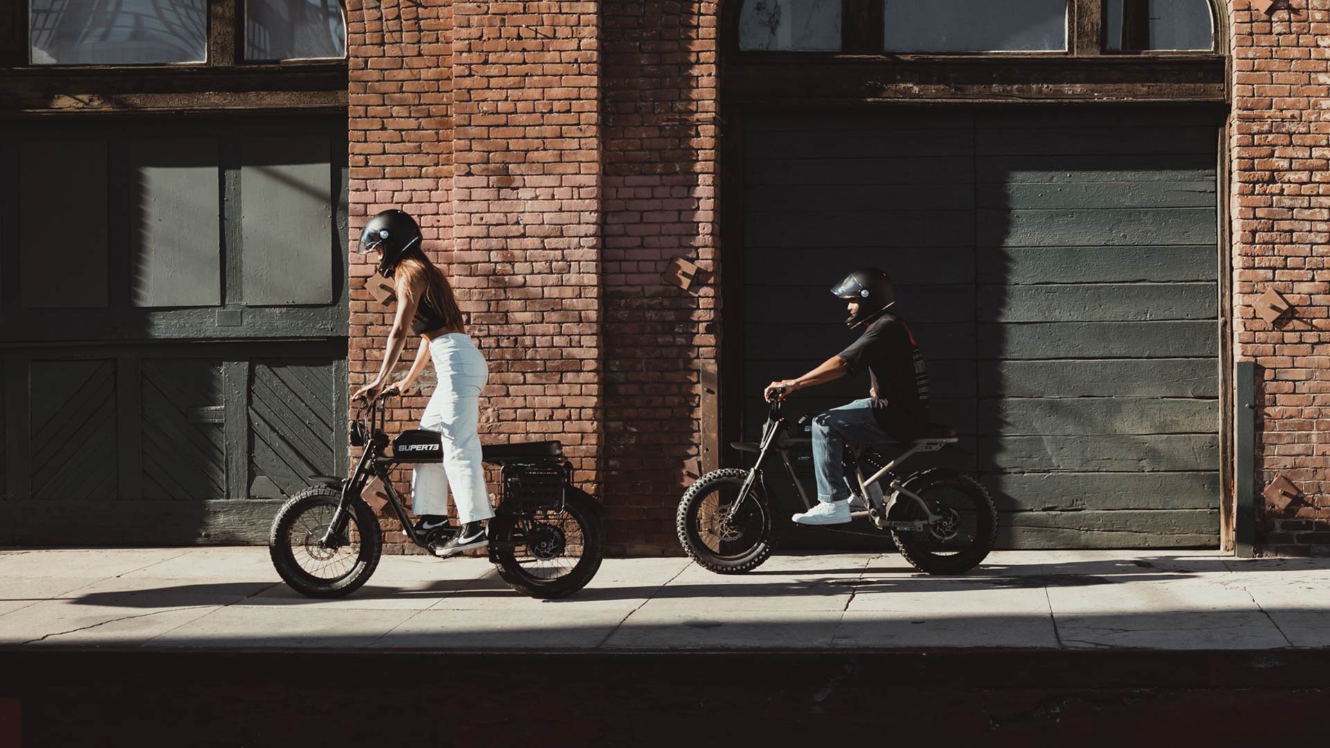 Two young riders on a street on Super73 ebikes