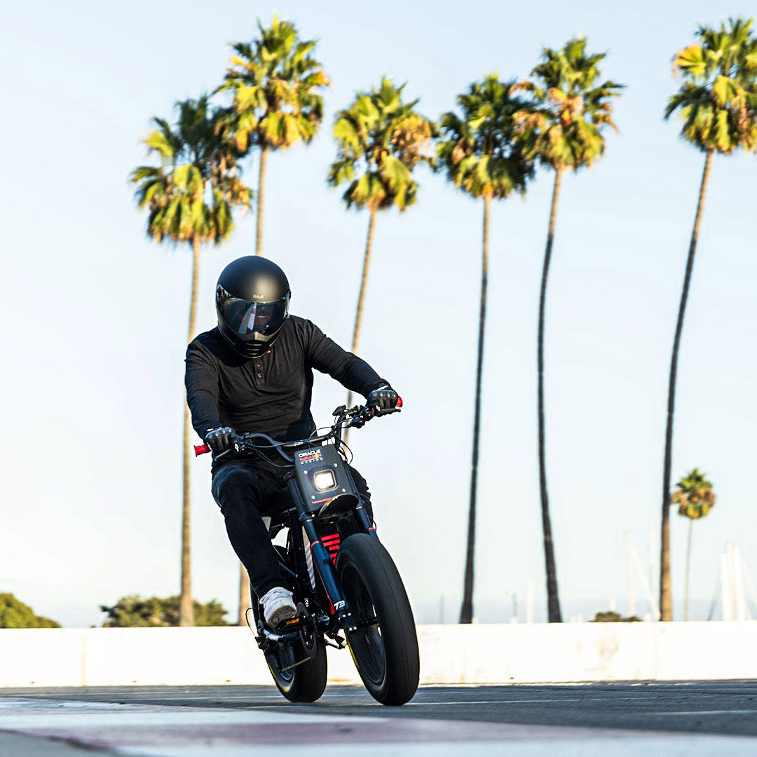 Lifestyle image of a man in a helmet riding the Oracle Red Bull Racing x SUPER73 R Adventure Series ebike