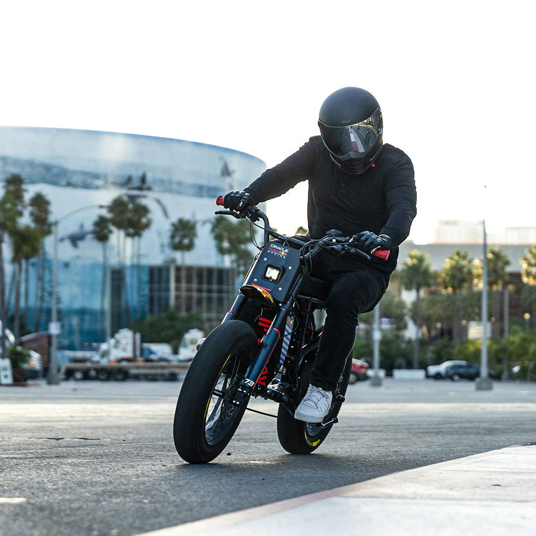 Lifestyle image showing a man in a helmet riding a Oracle Red Bull Racing x SUPER73 R Adventure Series ebike