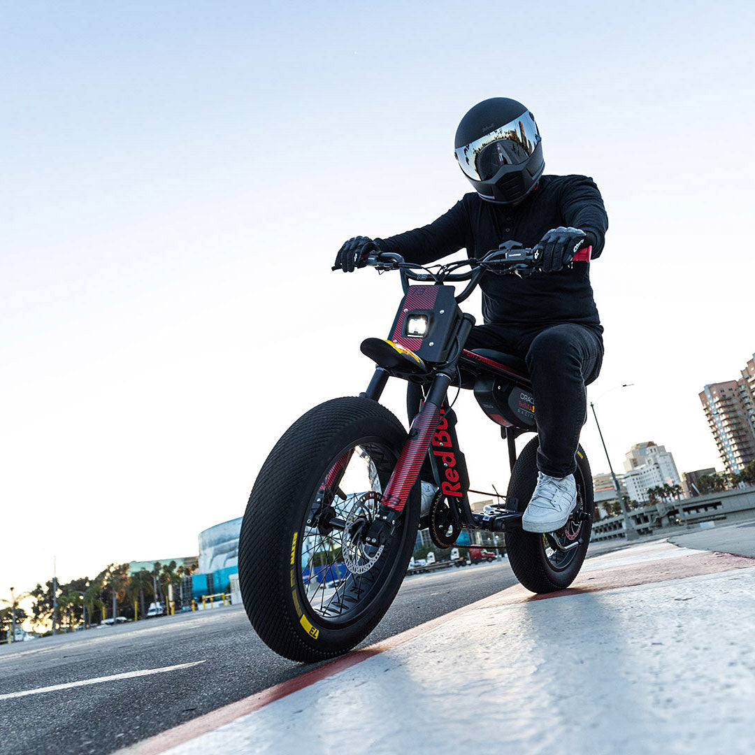 Lifestyle image of a man in a helmet riding the Oracle Red Bull Racing x SUPER73 Z Adventure Series ebike