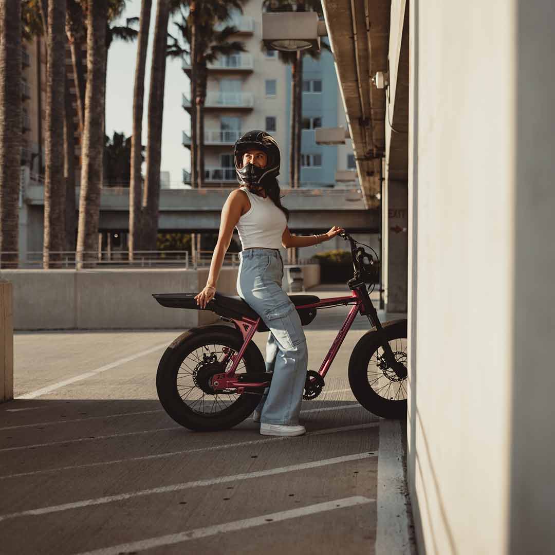 Young woman sitting on a SUPER73 ebike z miami in pink looking over her shoulder