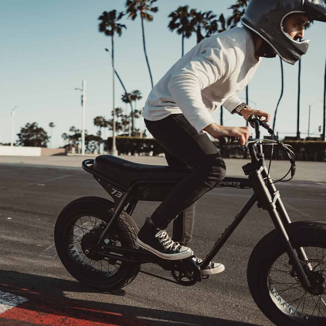A young man cruising out of frame on his obsidian super73 zx 