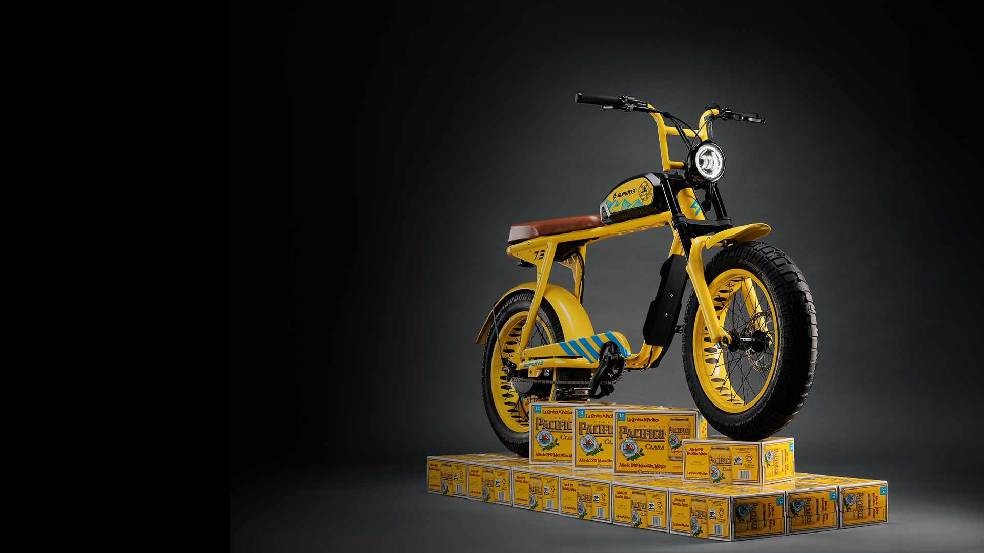A custom Pacifico x SUPER73-S2 bike is resting on a platform made from Pacifico beer cases.