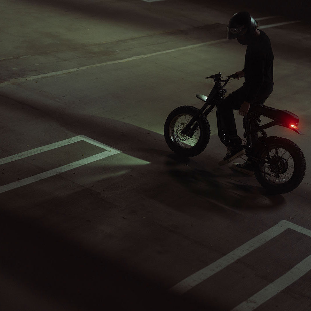 Lifestyle image of a man in a helmet on a SUPER73-R Adventure SE ebike in Bandit