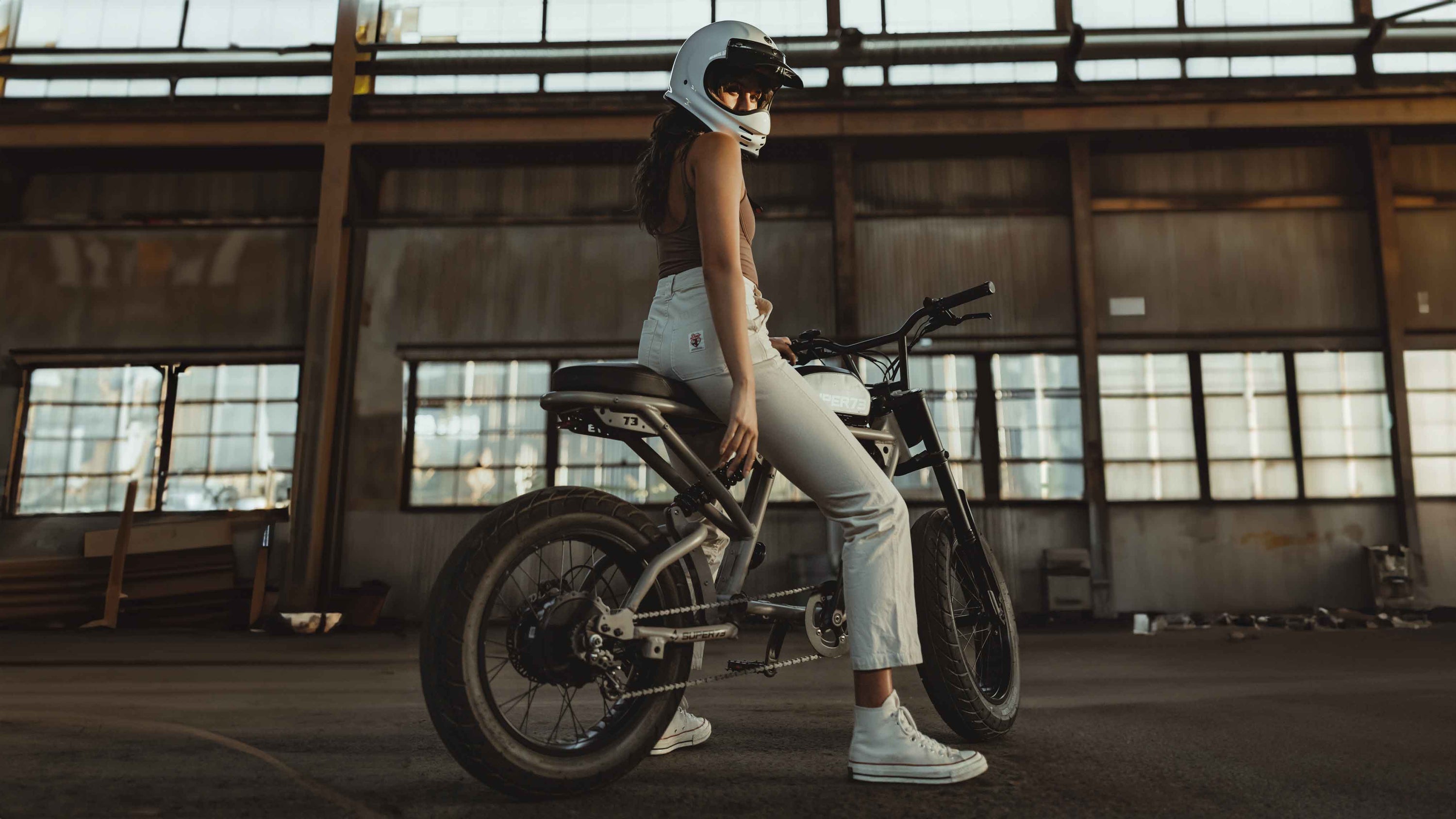 A young woman sitting on a SUPER73 R-Series ebike