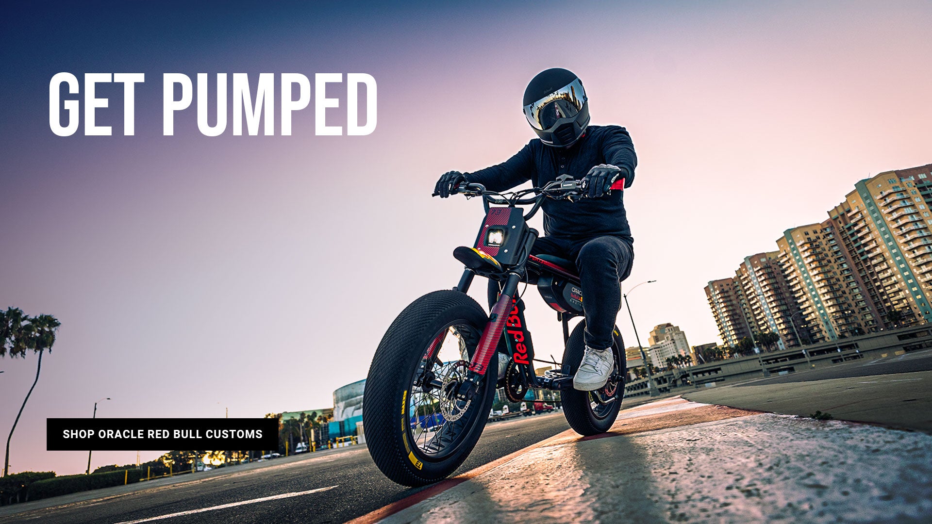 Lifestyle image of a man in a helmet riding the Oracle Red Bull Racing Z Adventure Series ebike