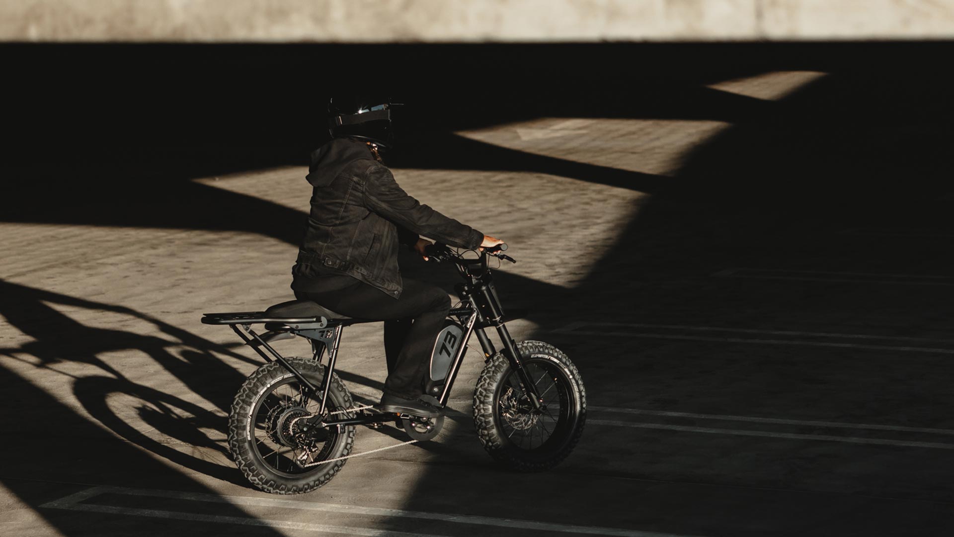 Image of a rider on the SUPER73-S Blackout SE bike in a parking garage.