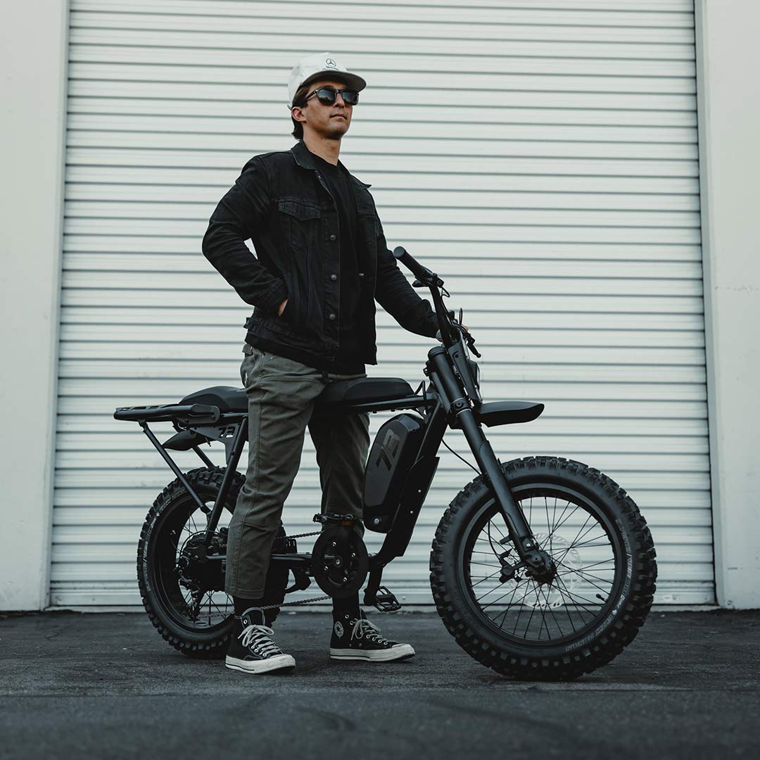 Image of a man standing with a SUPER73-S Blackout SE bike.