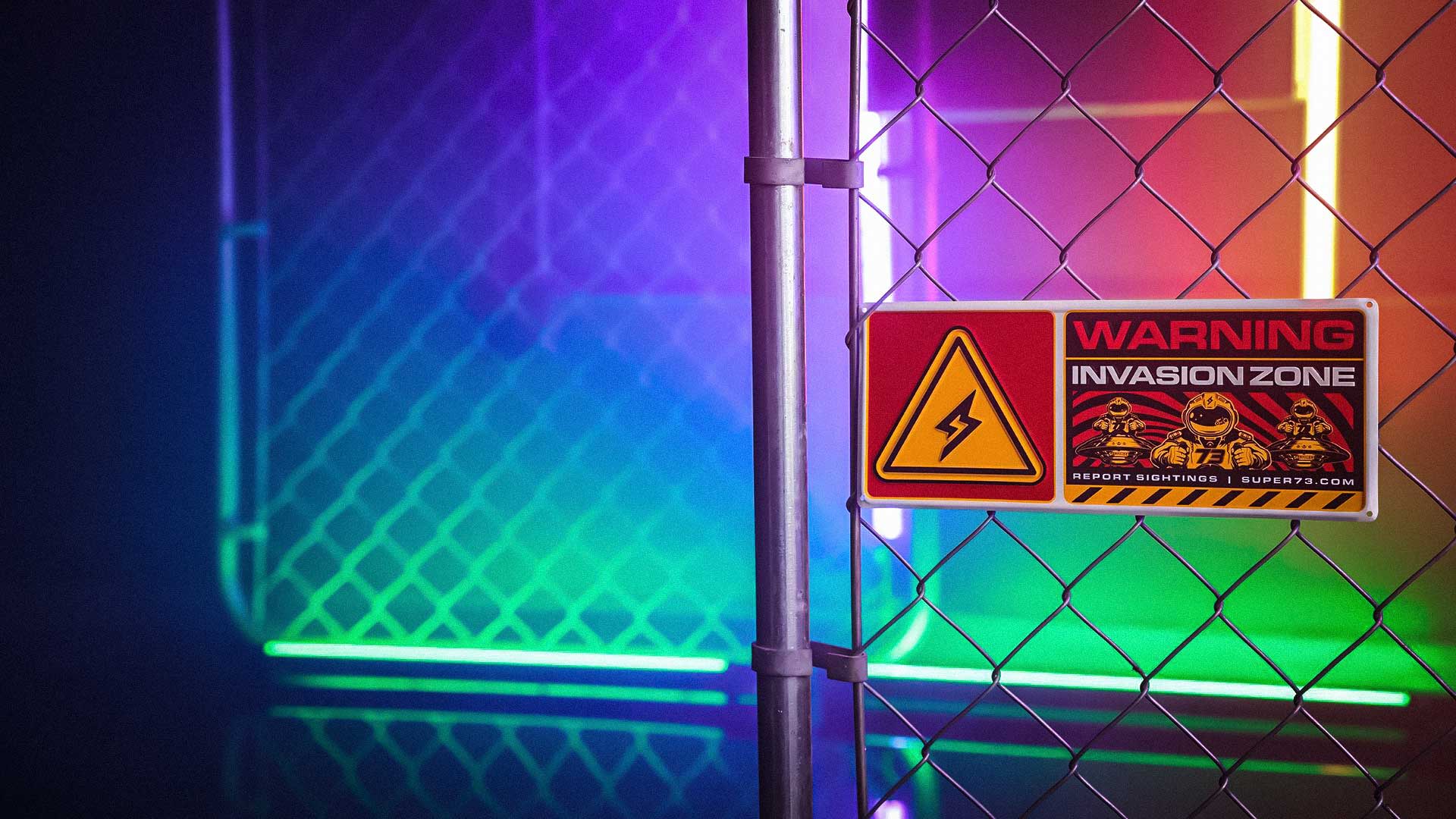 A metal sign that reads "warning invasion zone" attached to a metal cage