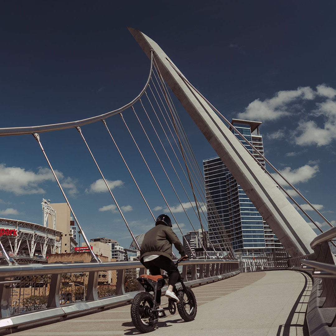 Lifestyle image of a man riding the SUPER73-Z Adventure SE ebike in Palladium on a bridge
