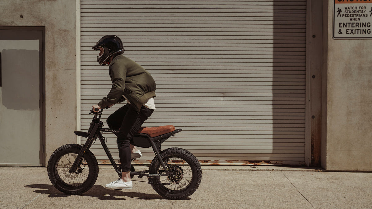 Lifestyle image of a man in a helmet riding the SUPER73-Z Adventure SE ebike in Palladium