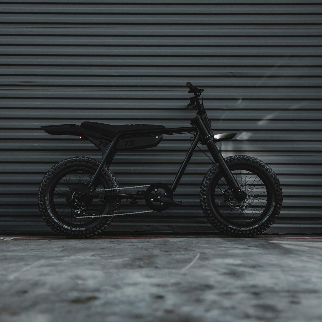 Image of a parked SUPER73-Z Blackout SE bike in front of a warehouse door.