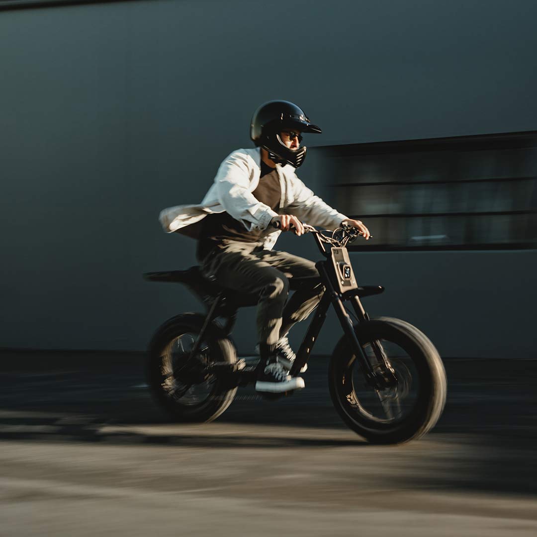 Image of a man wearing a helmet riding a SUPER73-Z Blackout SE bike.