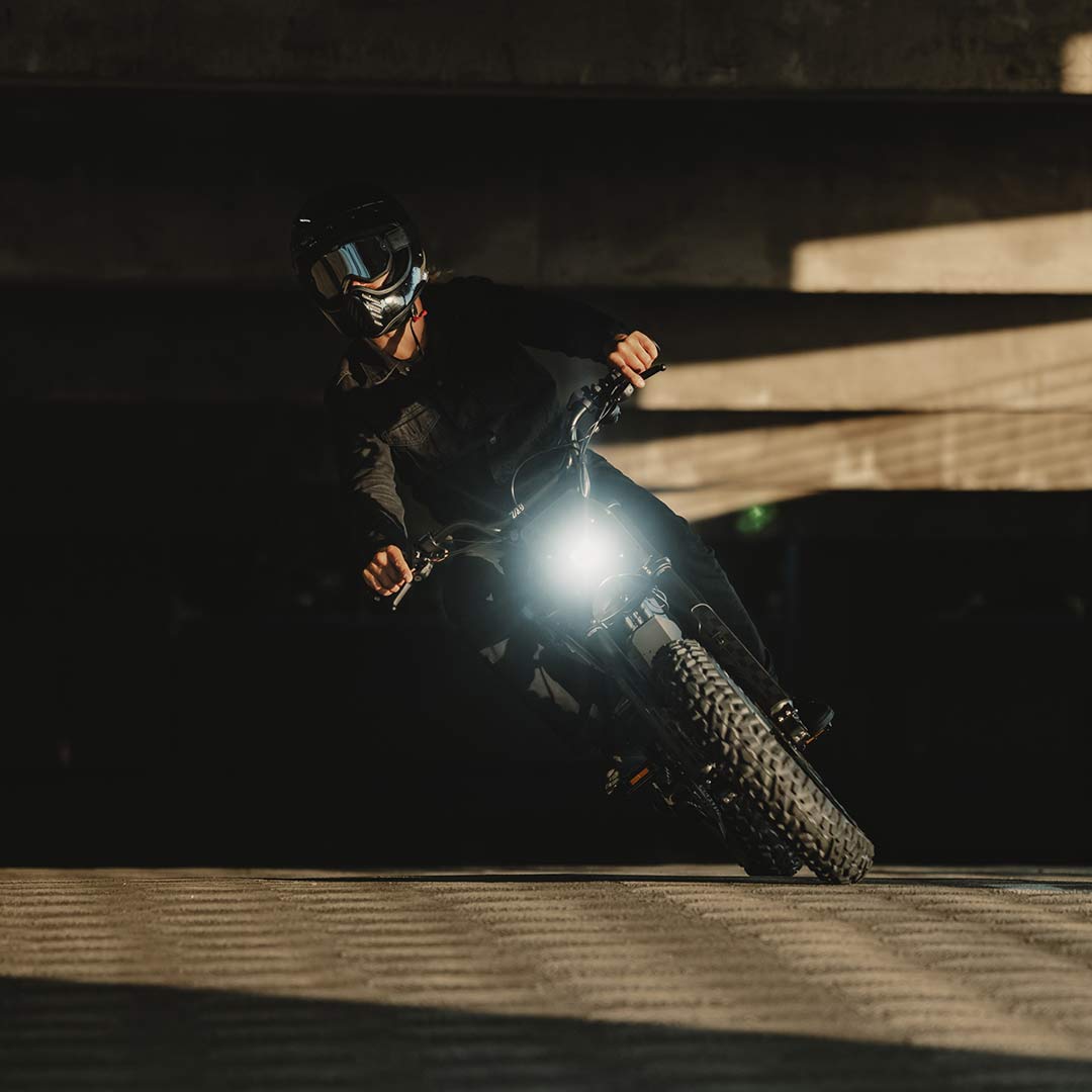 Image of a rider wearing a helmet and riding a SUPER73-Z Blackout SE bike in a parking garage.