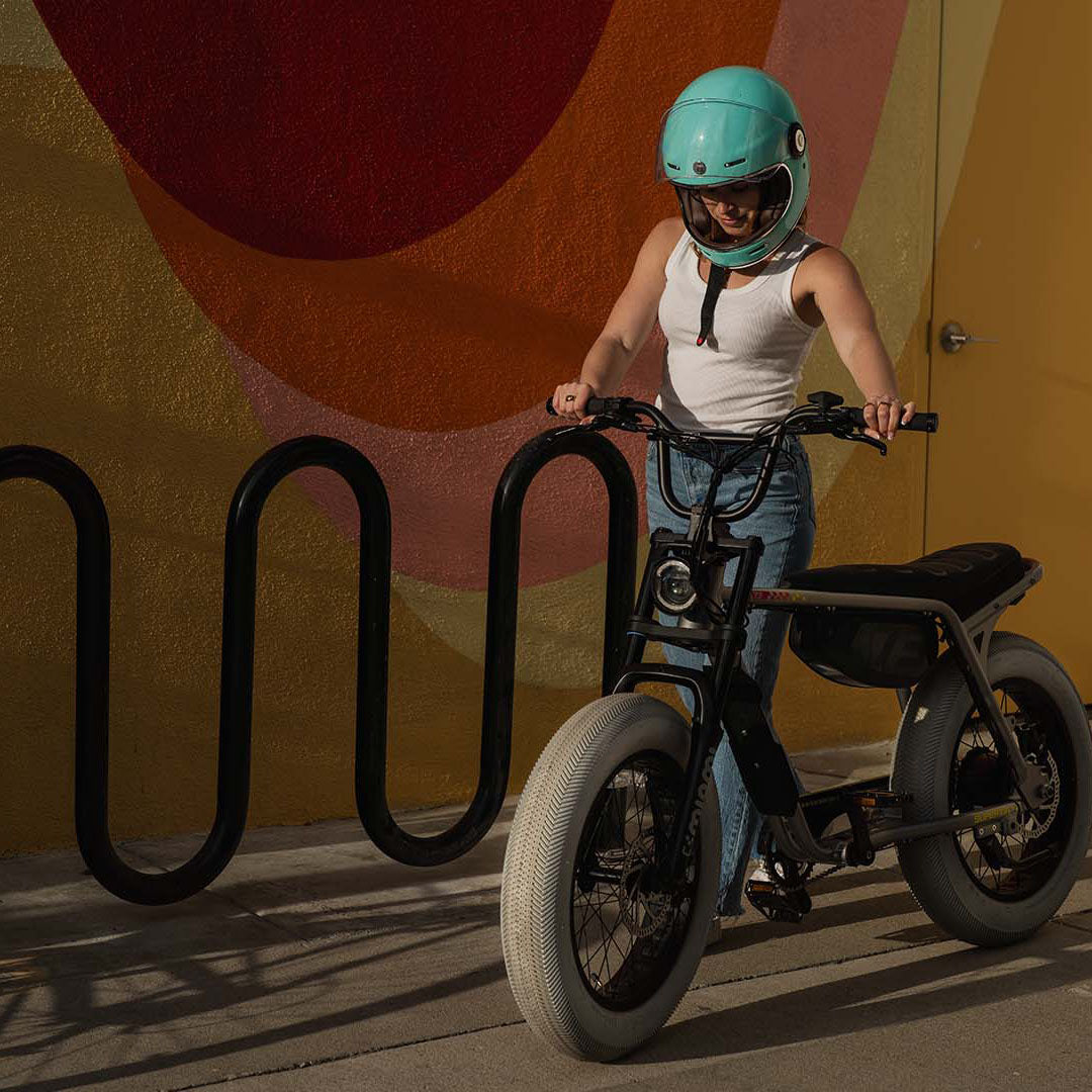 Lifestyle image of a woman standing next to the SUPER73-Z Miami LE ebike in Speedway