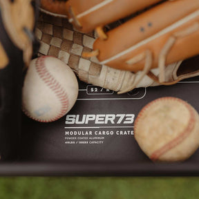 Close-up shot of a baseball glove and 2 baseballs inside a SUPER73 cargo crate.