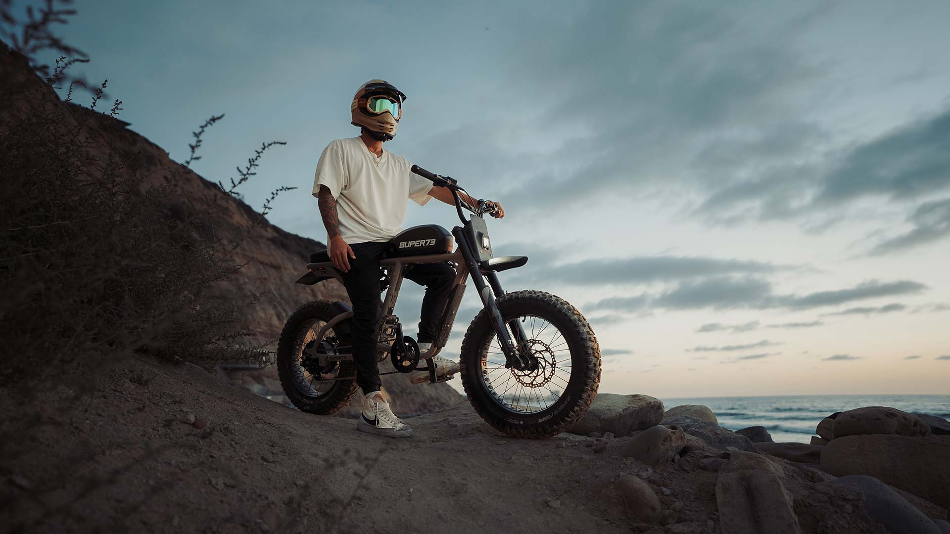 Young man sitting on a Super73 ebike on the side of a dirt mountain