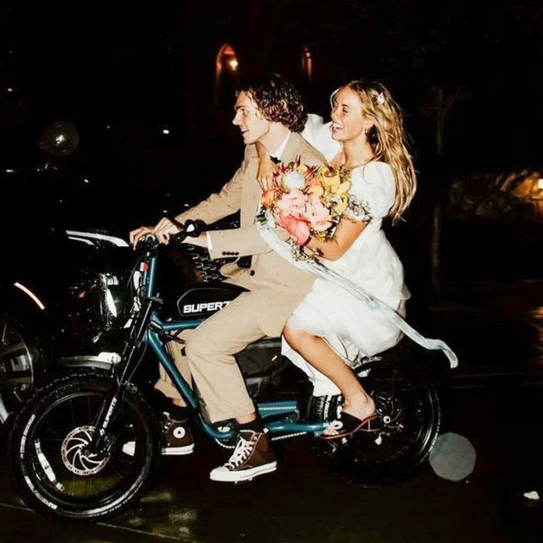 Lifesyle image of a couple on their wedding day riding away on their SUPER73 S2