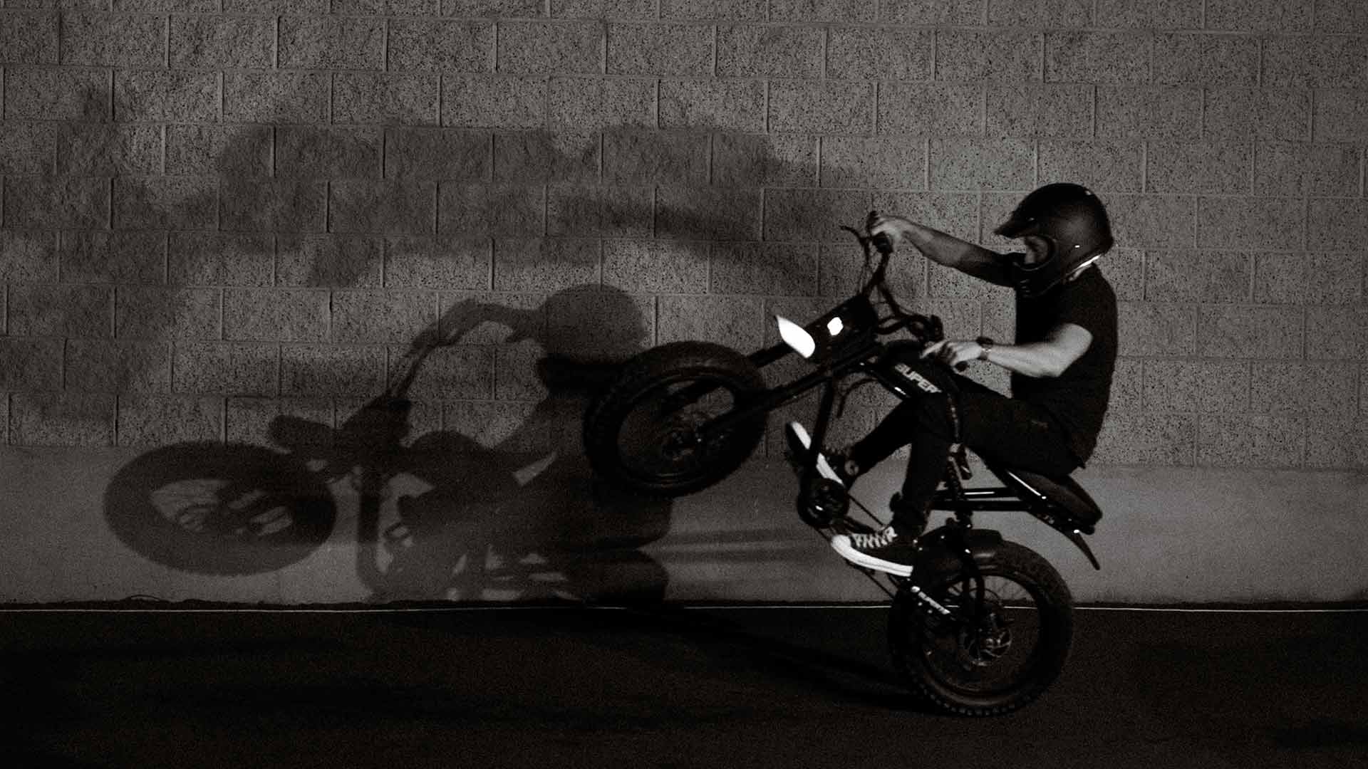 Black and white shot of Super73 RX Mojave ebike casting a wheelie shadow on concrete wall