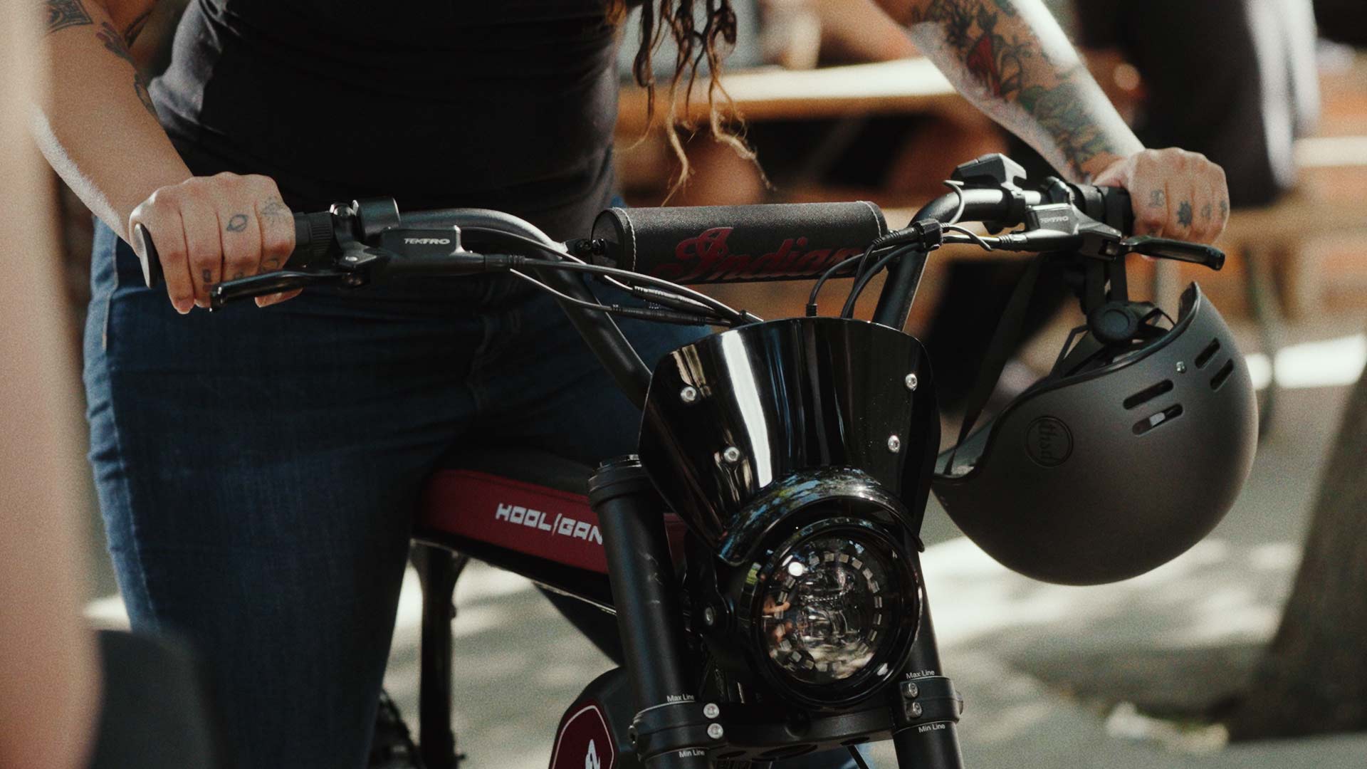 Closeup of handlebars of Super73 S2 Indian ebike with helmet hanging from handle