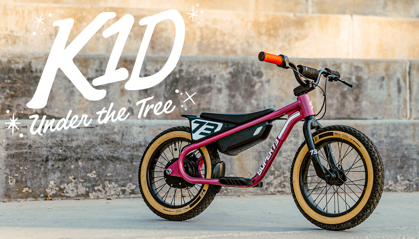 Lifestyle image of a Prickly Pink SUPER73-K1D parked in front of a concrete staircase.