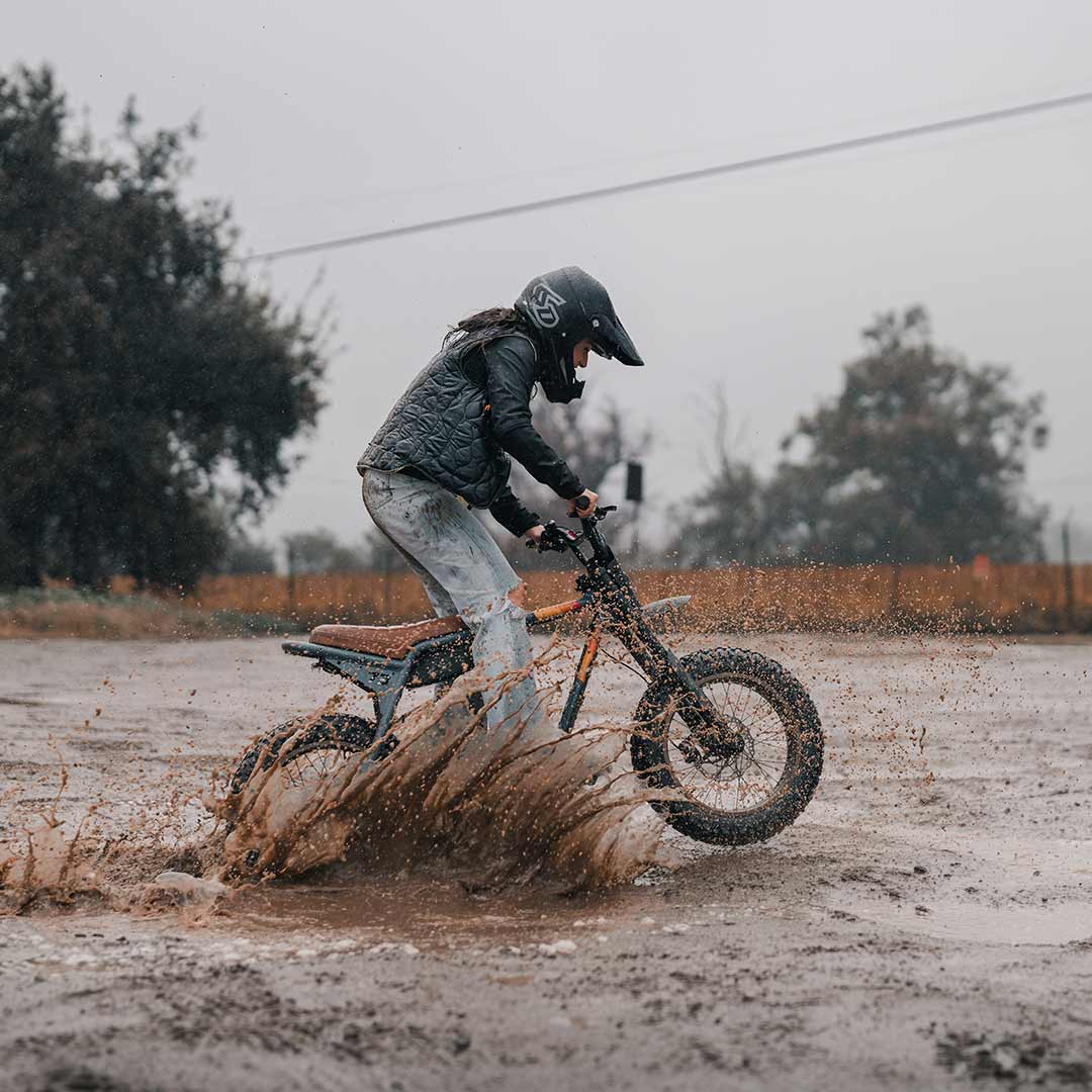 Female rider riding her Z Adventure in the mud while wearing a helmet.