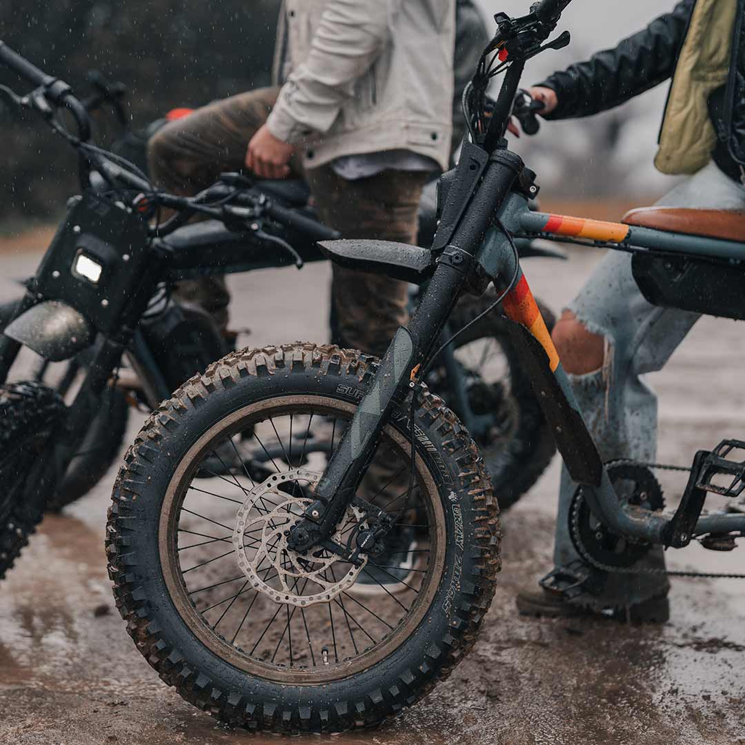 A group of riders hanging out on their Z Adventures in the mud getting ready to ride.