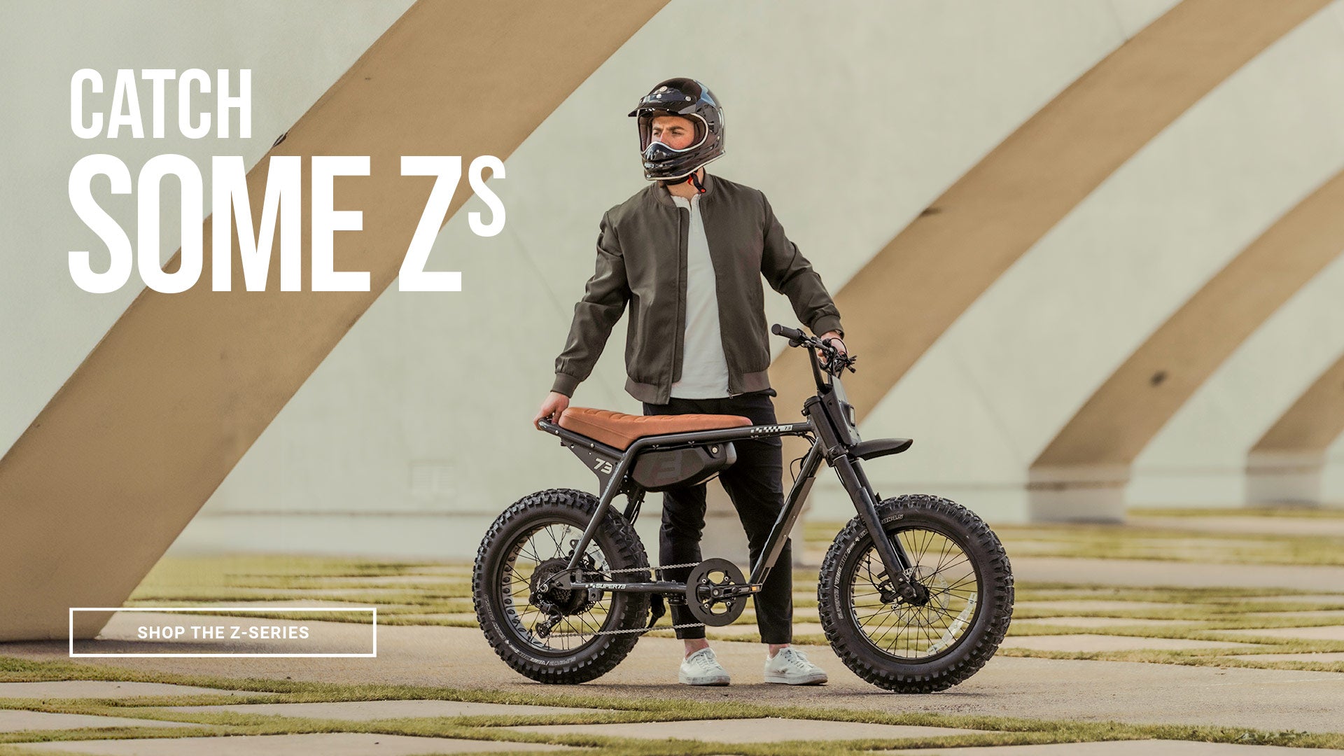 A man in a helmet stands next to a SUPER73-ZX SE ebike in Palladium. A text overlay says "Catch Some Zs"; click to shop the Z-Series.