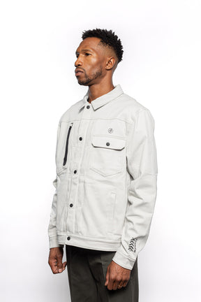 Side view of Male model wearing Anvil Chore Jacket in chalk colorway.