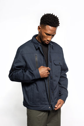 Male model zipping Anvil Chore Jacket in midnight colorway.