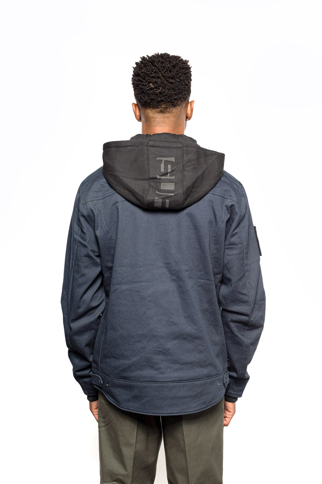 Back view of Male model wearing Chisel Hooded Jacket in midnight colorway.