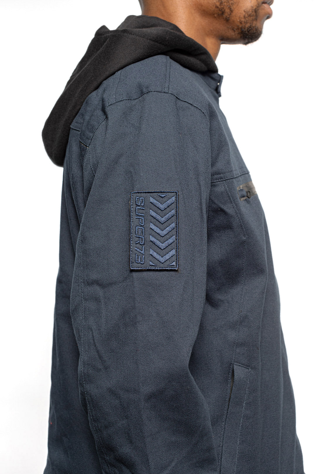 Side sleeve detail view of Male model wearing Chisel Hooded Jacket in midnight colorway.
